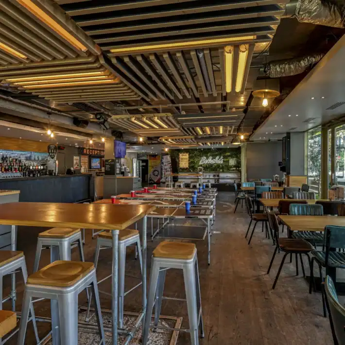 Modern bar and restaurant interior with TV screens for World Cup viewing.