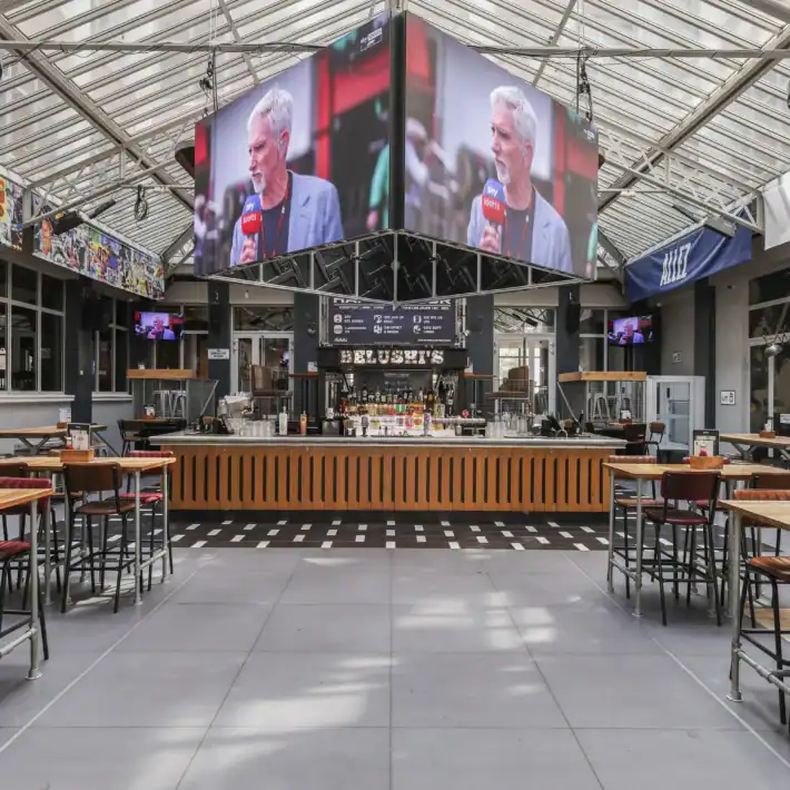 Indoor sports bar with large screens showing football match at Gare du Nord.