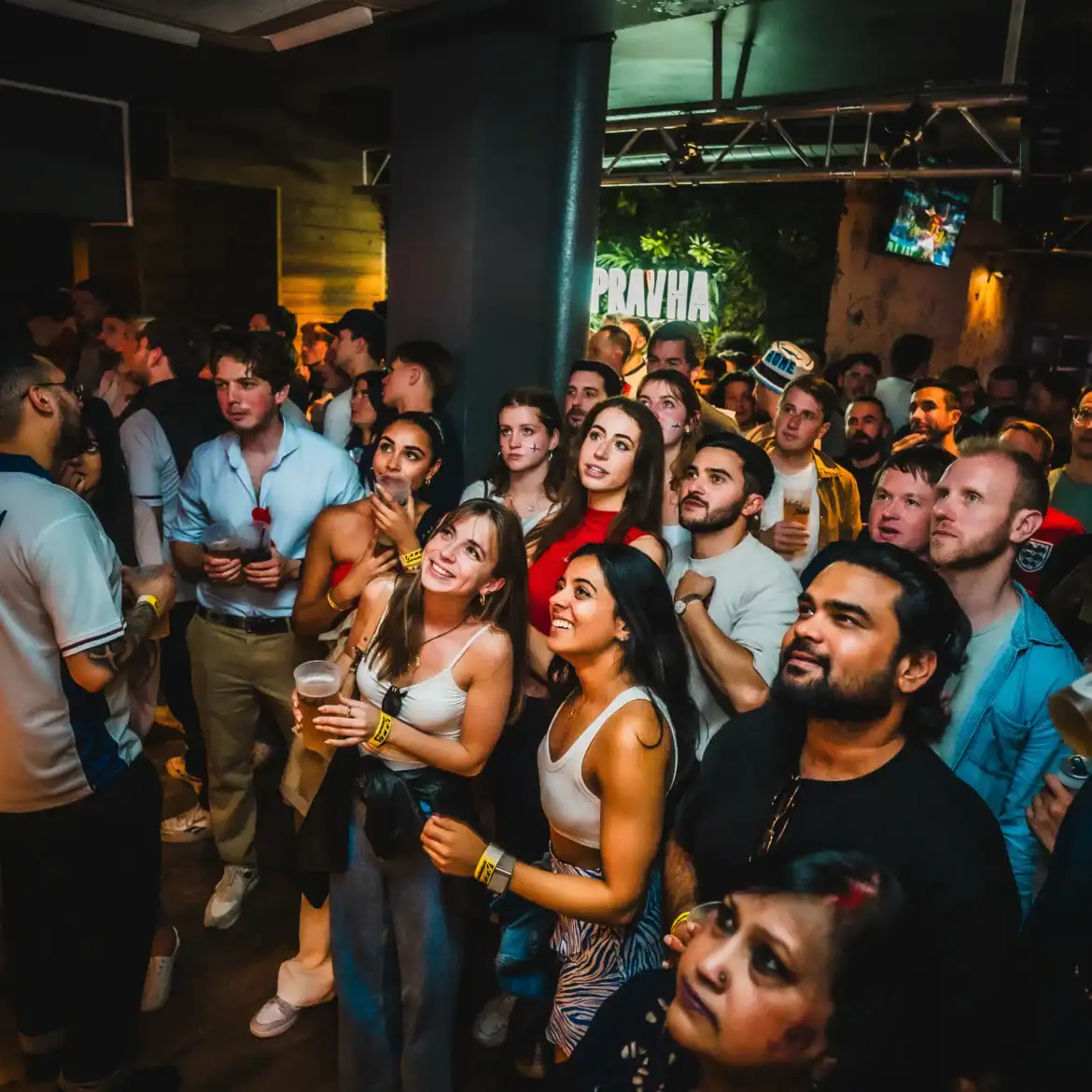 Diverse crowd of international football fans watching the World Cup live together at Belushi's sports bar generating an electric match day atmosphere