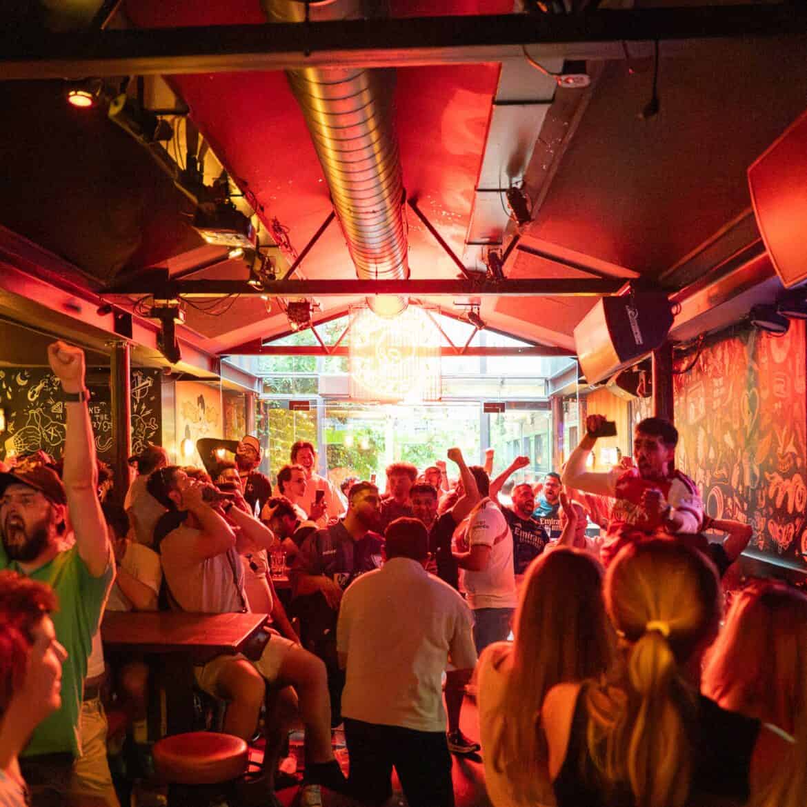 Crowd enjoying live World Cup match at Belushi's pub.