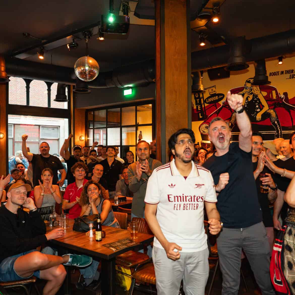 Crowd celebrating at Belushi's during World Cup event in a lively pub.