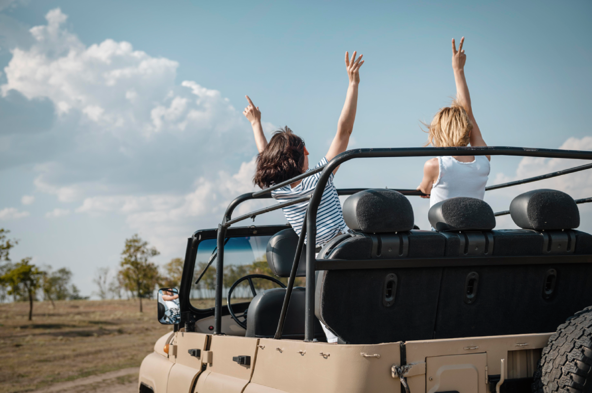 female-friends-having-fun-traveling-in-safari