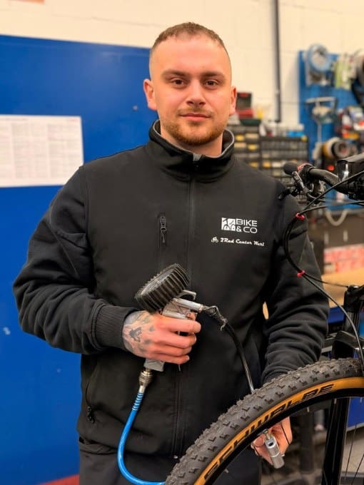 Mitarbeiter im 2Rad Center Werl mit Fahrrad und Werkzeug.