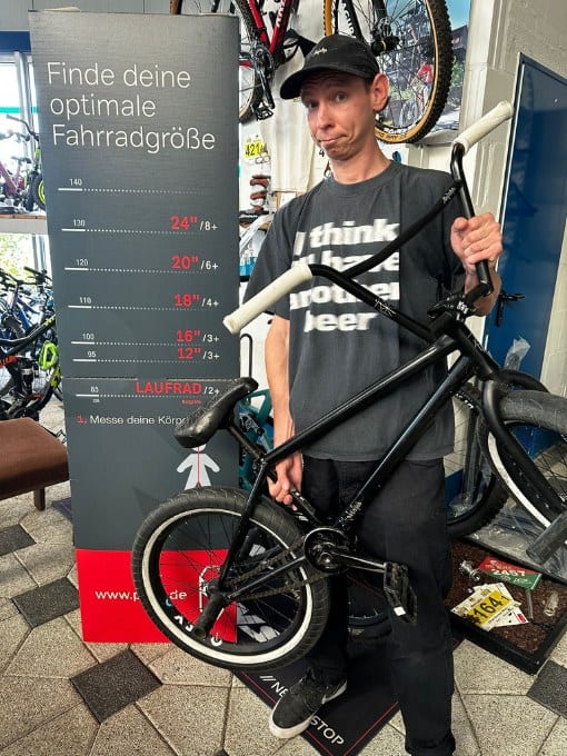 Mann hält Fahrrad im Fahrradgeschäft bei 2Rad Center Werl.