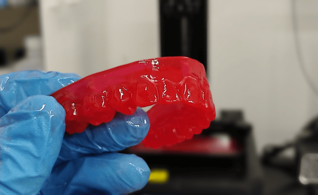 Molde de dientes de plástico en color rojo utilizado en impresoras 3D.
