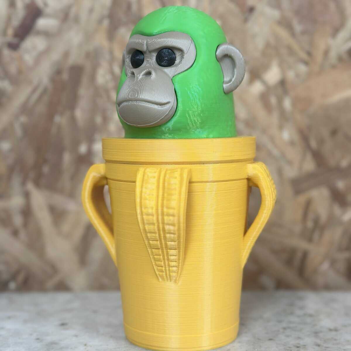 3D Casa Bureu Plásticos, figura de macaco en 3D impresa en filamento, con recipiente decorativo en color amarillo, perfecta para decoración o souvenirs, fabricada con tecnología de impresión 3D de alta calidad.