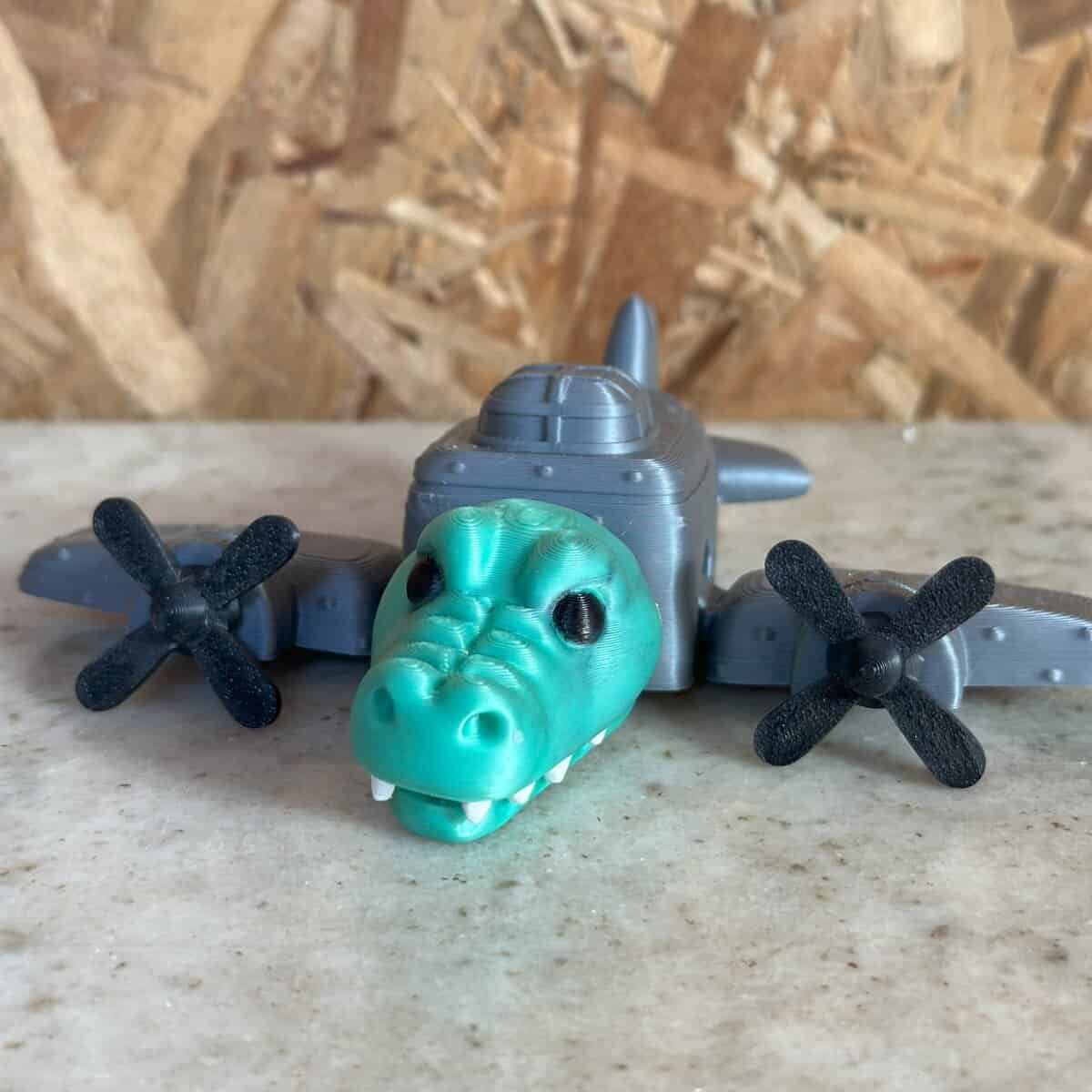 Mini dron con cabeza de dinosaurio en plástico 3D, fabricado por 3D Casa Bureu Plásticos, ideal para niños y coleccionistas, con diseño innovador y materiales duraderos hechos en Argentina.