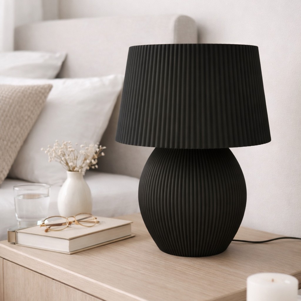 Lámpara de mesa negra con diseño moderno y texturizado, ideal para decorar y iluminar espacios interiores con estilo y elegancia. Perfecta para salas, dormitorios o áreas de descanso.