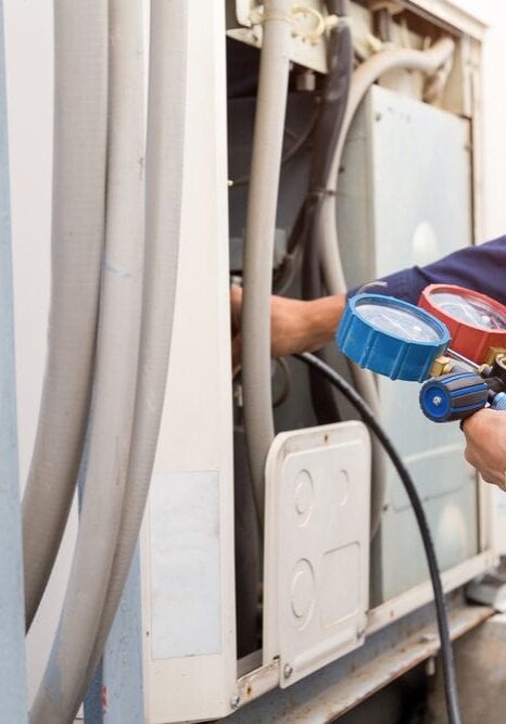 HVAC-Technician-Using-Refrigerant-Gauge-On-AC-Condenser