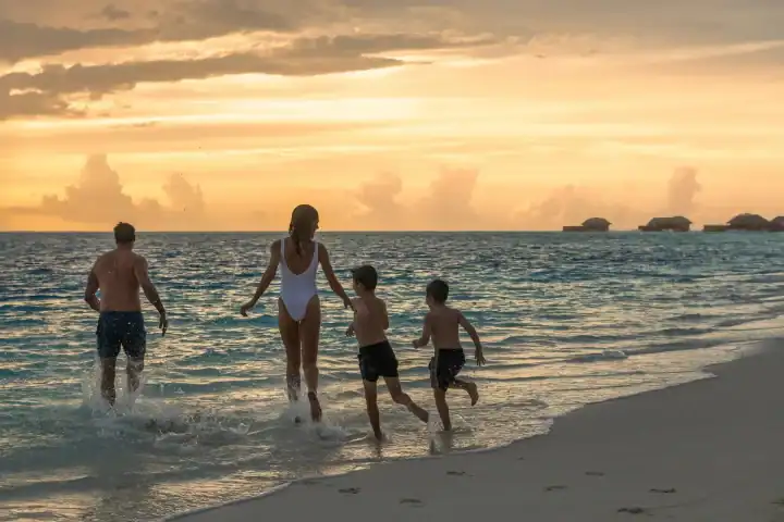 Family on the beach at sunset