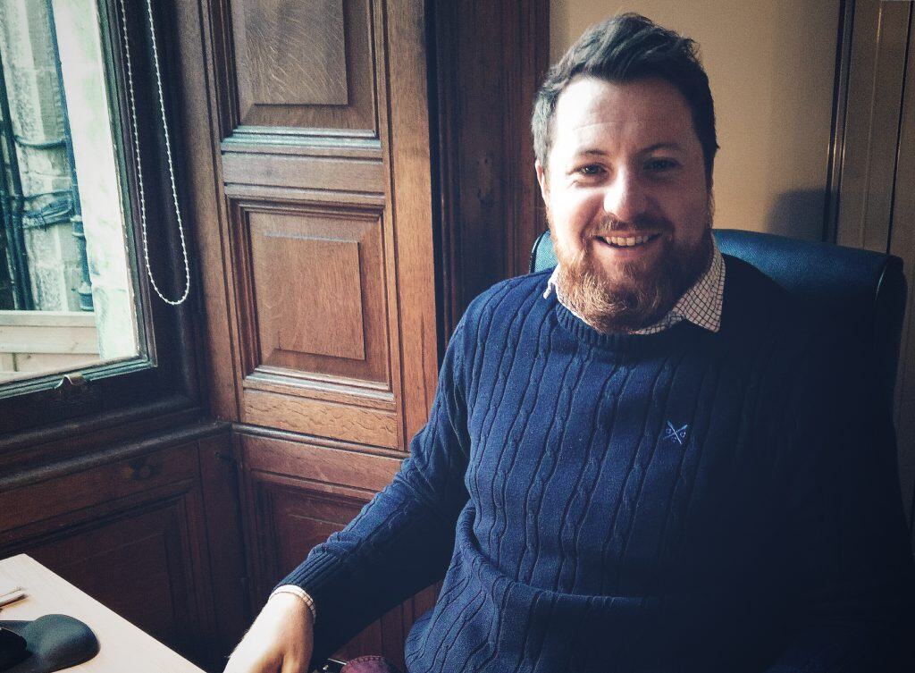 A professional architect working in a classic wood-paneled office, showcasing modern architectural office solutions.