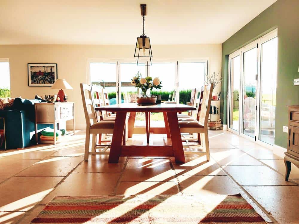 Bright family dining area with contemporary furniture, large glass doors, and scenic garden views.