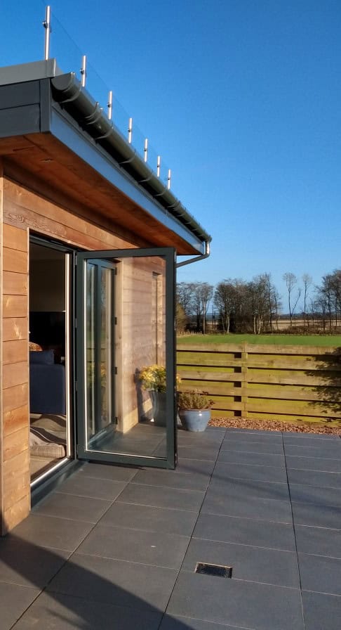 Contemporary wooden house with an open patio, ideal for relaxing outdoor living and enjoying countryside scenery.