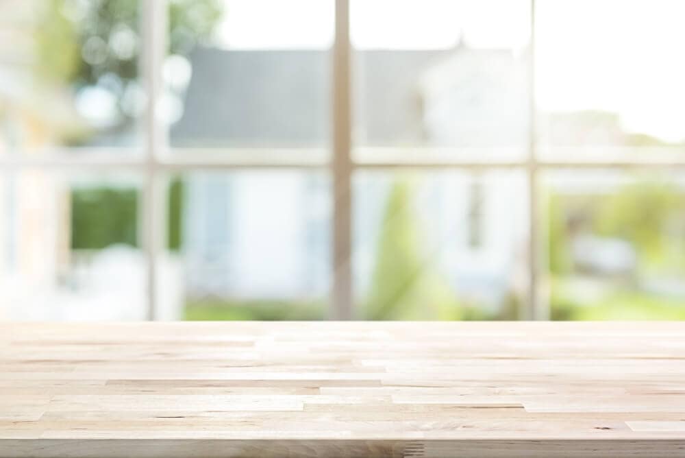 Bright, airy architectural interior with floor-to-ceiling windows and wooden surface.