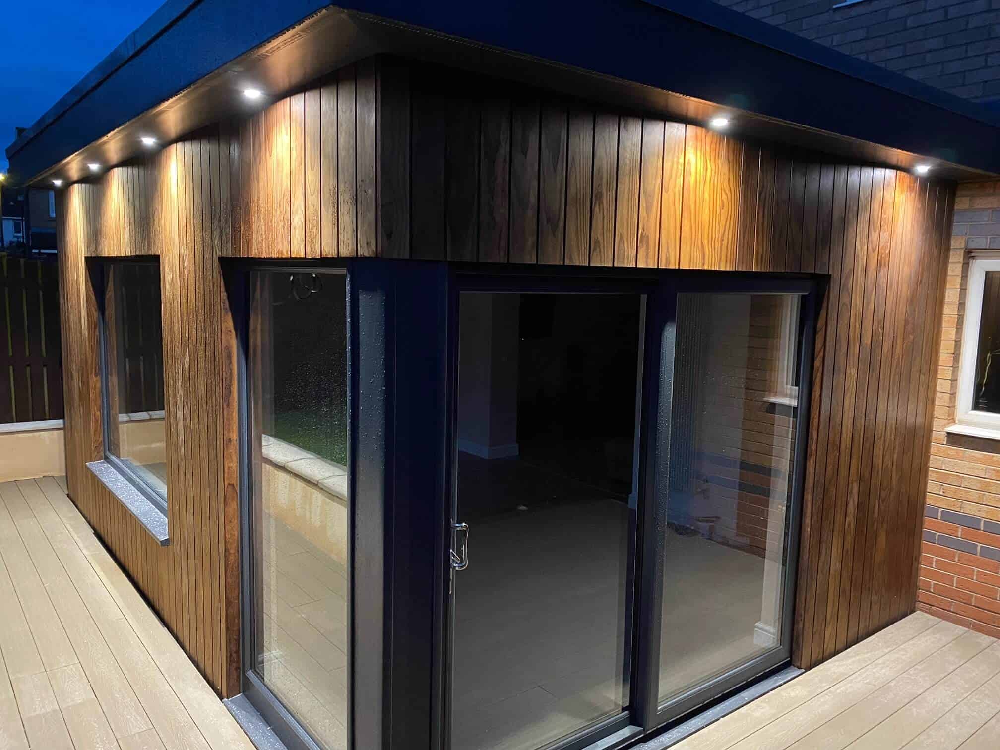 Innovative timber extension featuring large sliding glass doors and subtle outdoor lighting.