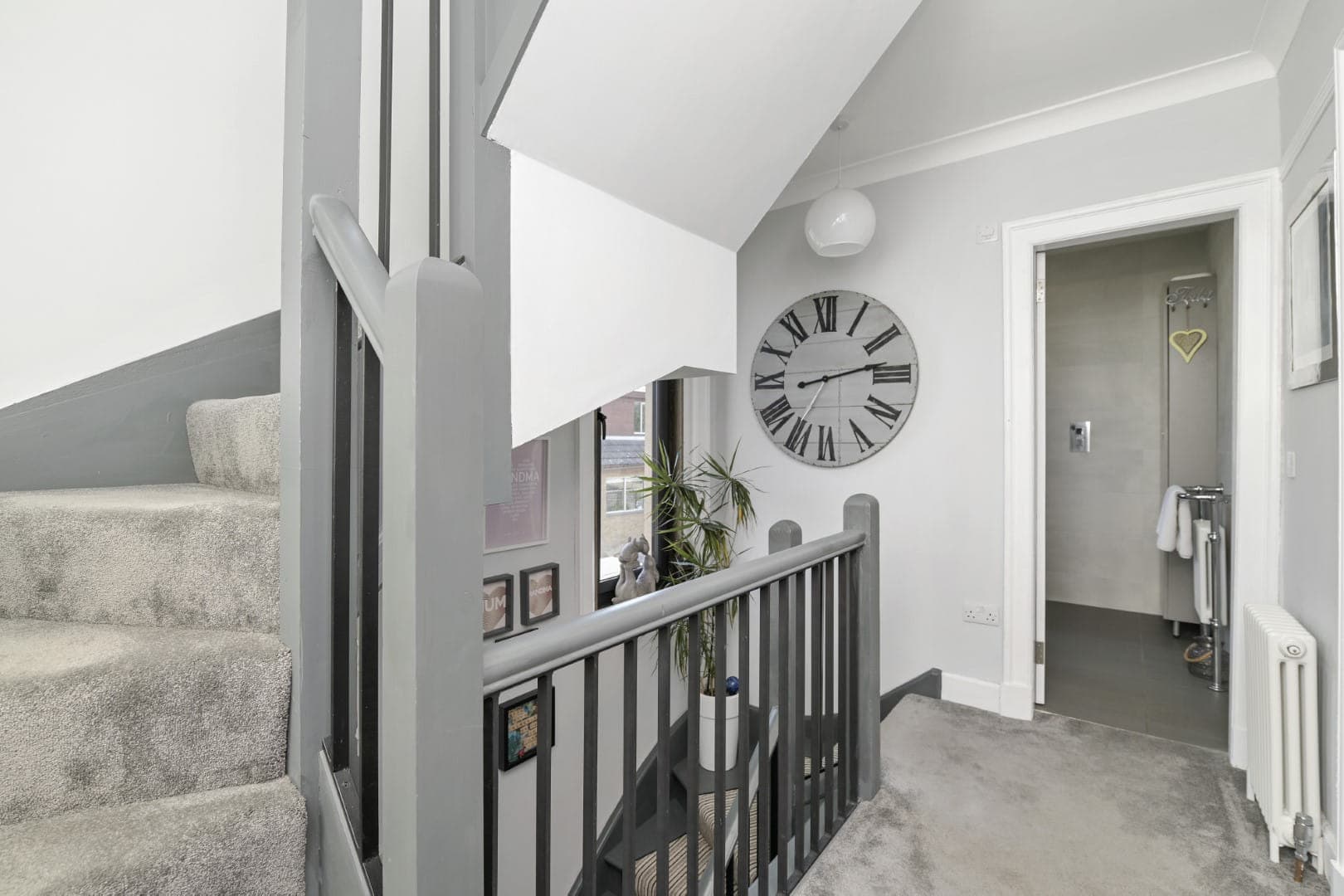 Bright, contemporary home staircase with elegant decor and clock feature.