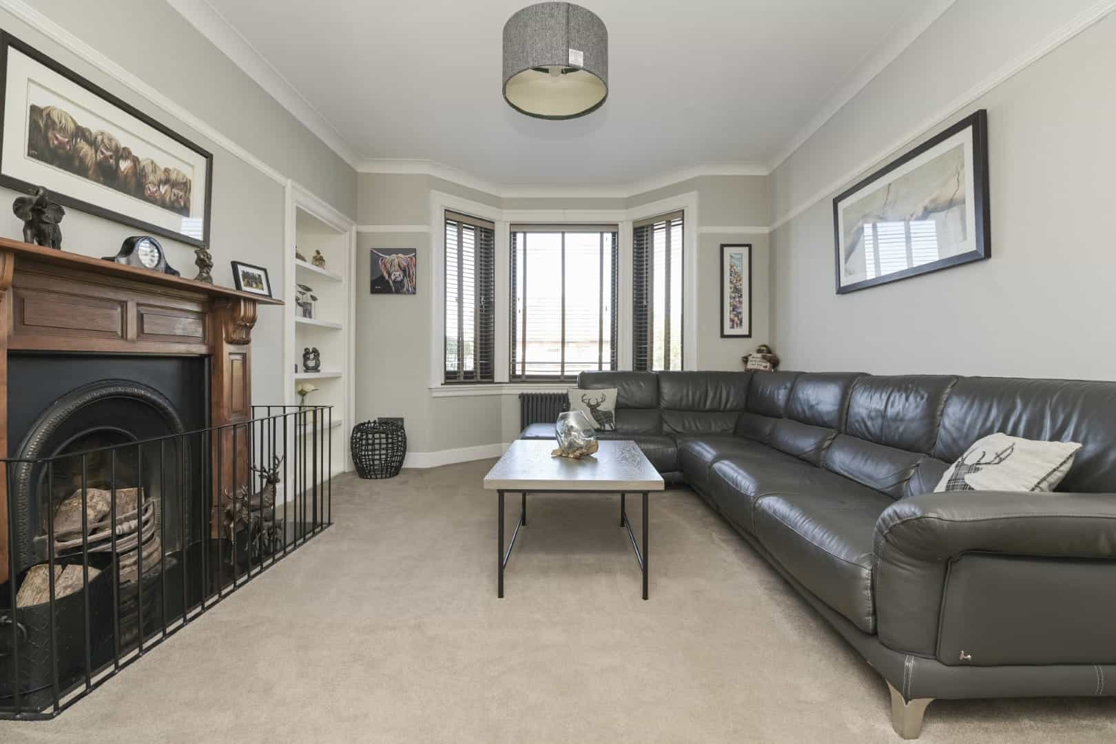 Spacious living room with grey walls, large bay window, and contemporary decor.
