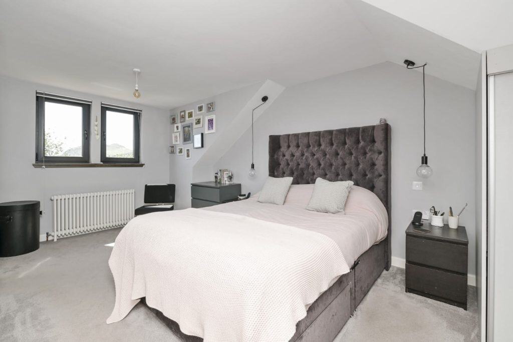 Contemporary bedroom design with grey tones, stylish pendant lights, and personalised wall art.