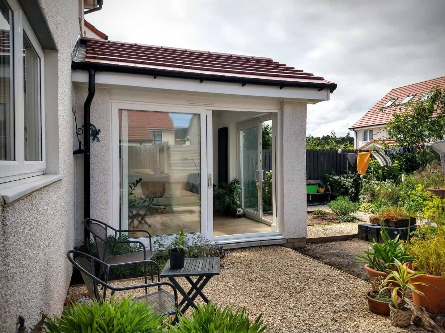 Bright and spacious sunroom with glass sliding doors, perfect for garden relaxation and outdoor dining.