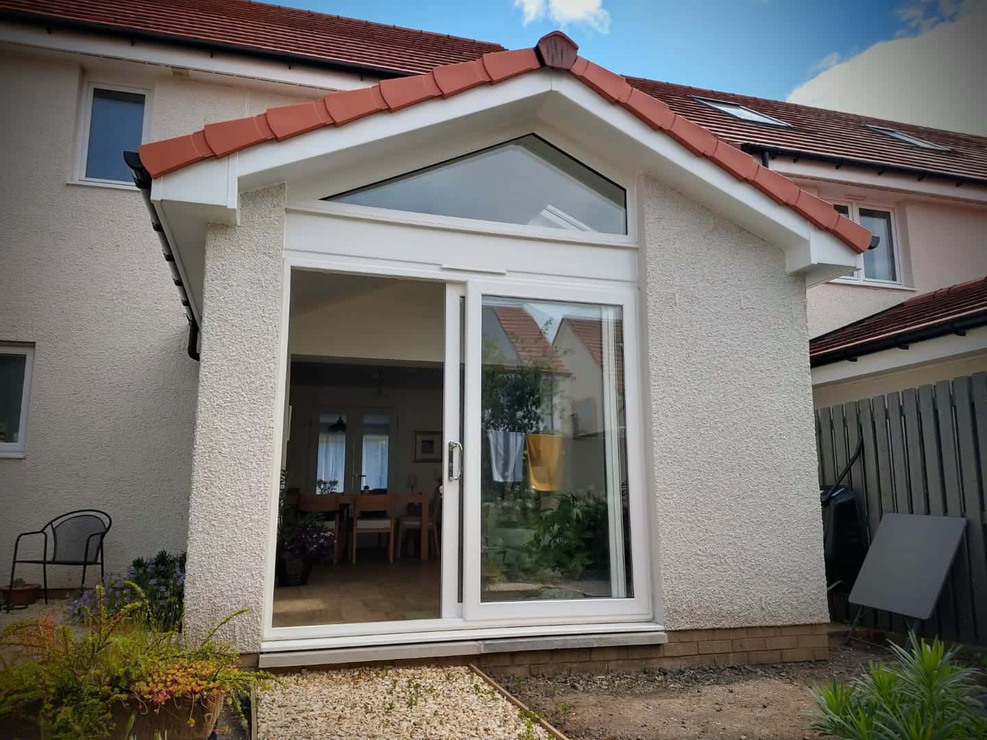House extension with glazed sliding doors, brick and render exterior, enhancing indoor-outdoor flow.