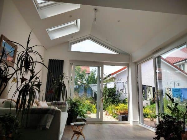 Bright living room with skylights and large windows for natural light and garden view.