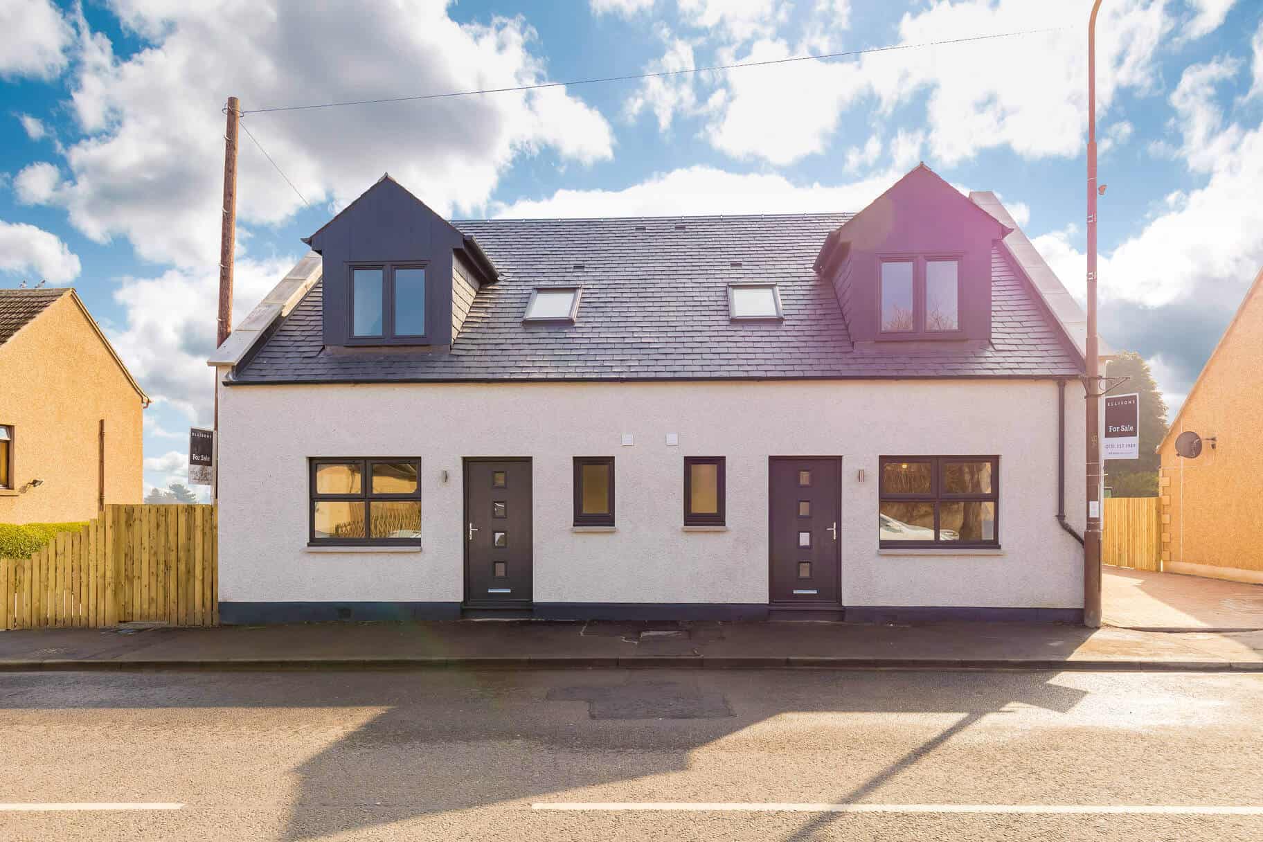 Bright, contemporary residential home with dormer windows and sleek exterior, located in a suburban neighbourhood.