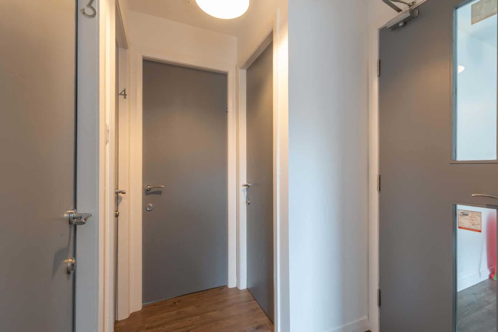 Interior of contemporary office with sleek grey doors and natural lighting.