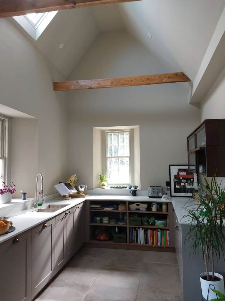 Bright modern kitchen with natural light and wooden beam accents.
