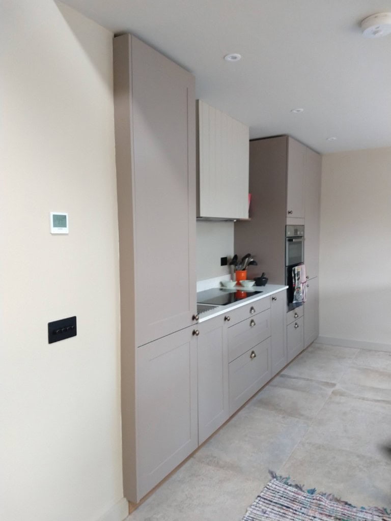 SEO-friendly alternative text for the image of a contemporary beige kitchen with built-in appliances.