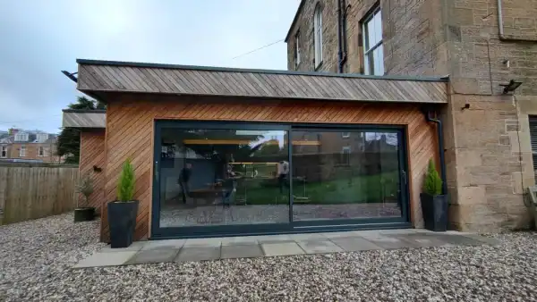 Bright, modern extension designed by ABC Architecture with wood facade and generous glass frontage.