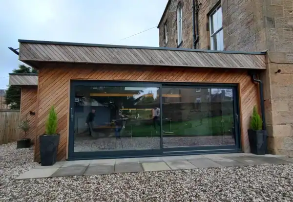 Bright, modern extension designed by ABC Architecture with wood facade and generous glass frontage.