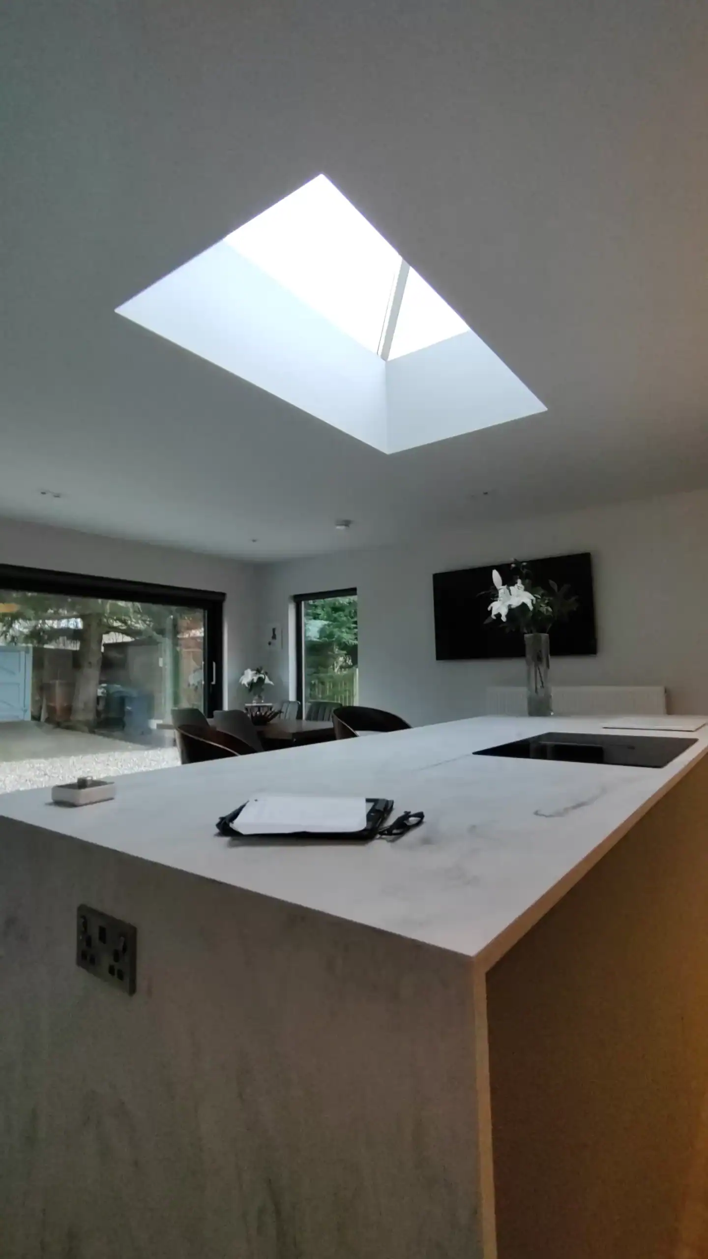 Bright modern kitchen featuring a skylight and open-plan dining space in contemporary style.