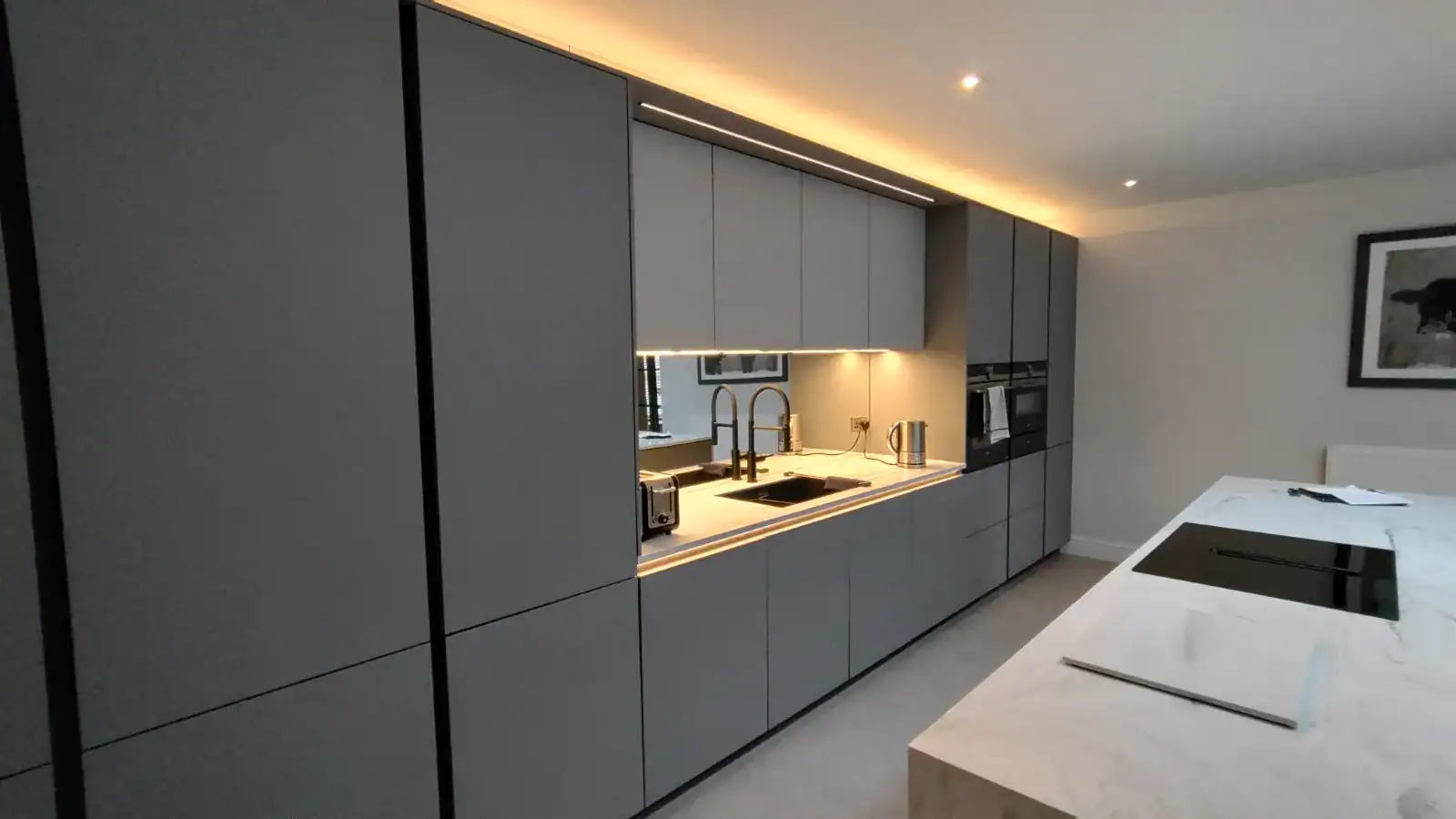 Modern grey kitchen with built-in appliances and sleek cabinetry. Minimalist grey kitchen design with integrated appliances and contemporary cabinetry for stylish living.