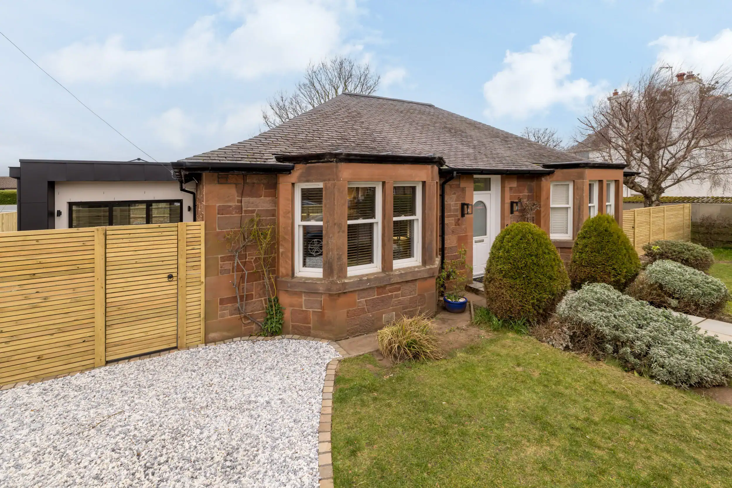 Spacious front garden with landscaped greenery and decorative gravel pathway. Perfect blend of classic and modern architecture.