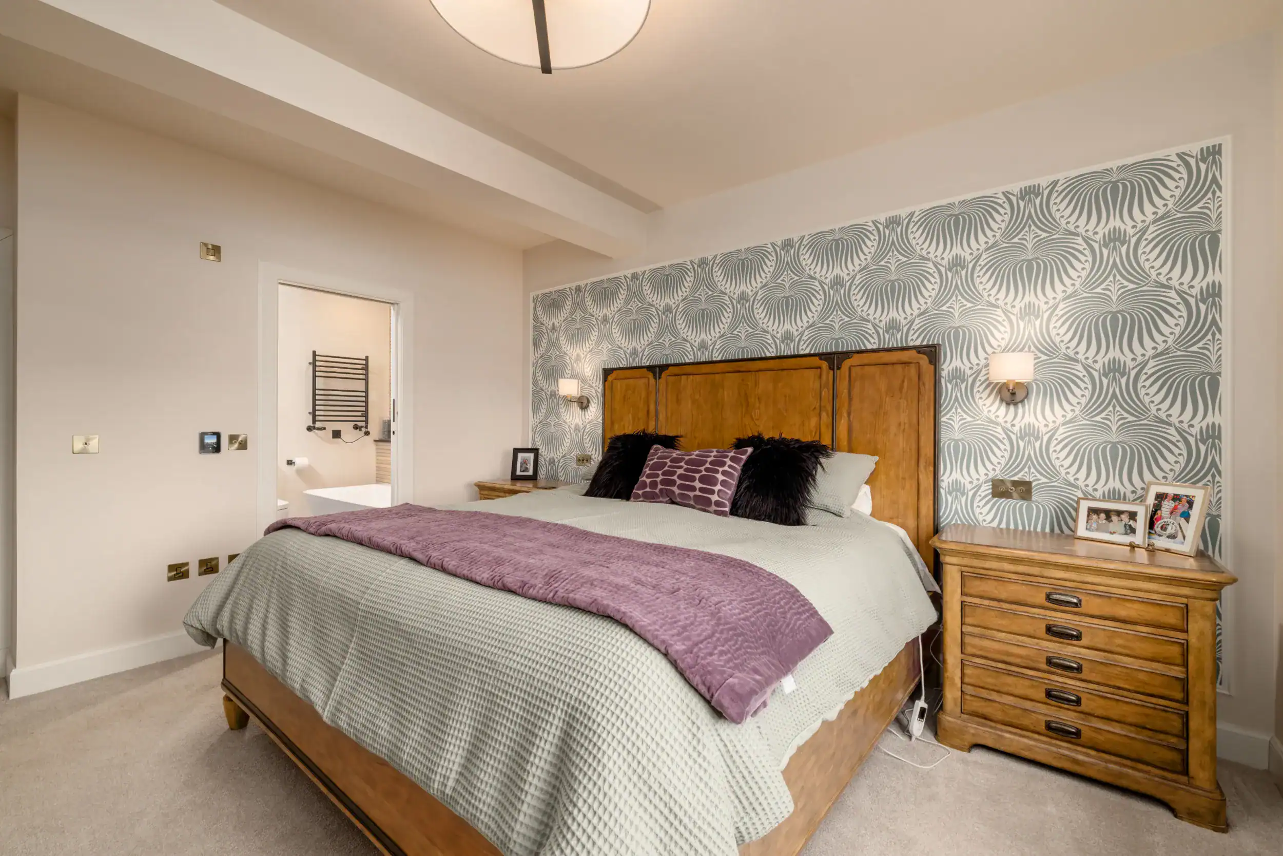 Elegant bedroom interior featuring wooden furniture and stylish wallpaper.