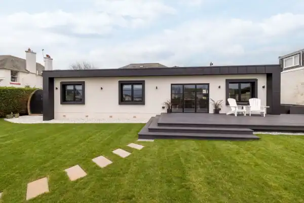 Stunning modern house featuring sleek black window frames and a spacious outdoor deck, designed by ABC Architecture.