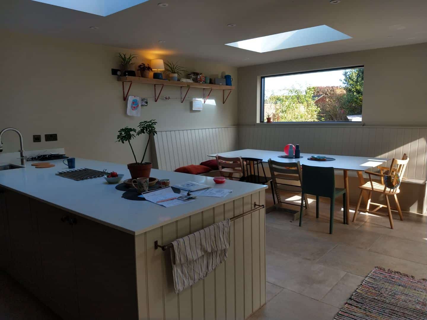 Bright kitchen with skylight and dining area, featuring minimalist design and natural sunlight, exemplifying contemporary architecture.
