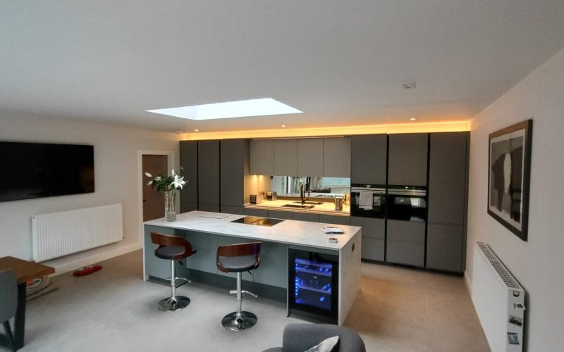 Image of a contemporary kitchen featuring minimalist cabinetry and an island with built-in wine cooler.