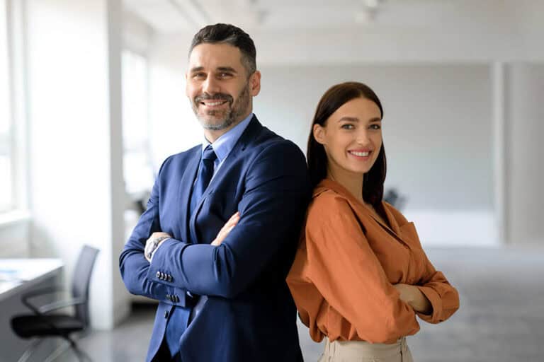 Stock photo two successful businesspeople standing back to back with arms crossed and smiling at camera posing 2280495333