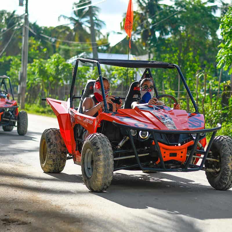 Punta Cana Exciting off-road buggy ride through lush Punta Cana landscape with tourists enjoying the adventure.