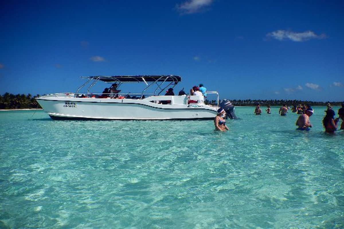 Punta Cana Boat tour in Punta Cana with tourists swimming and enjoying the clear turquoise water.
