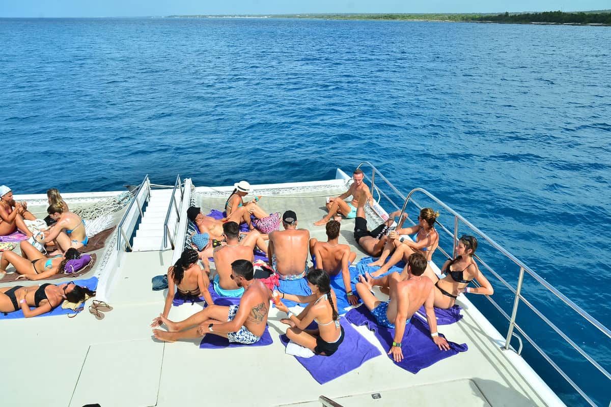 Punta Cana People practicing yoga on a catamaran in the ocean.