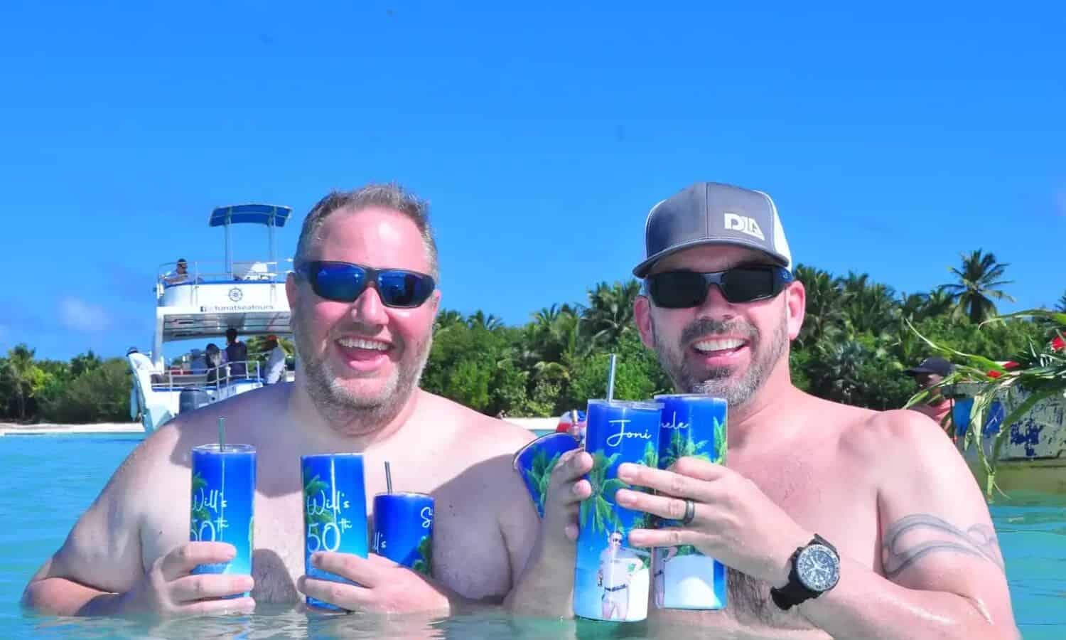 Punta Cana Two men enjoying drinks on a catamaran during a Punta Cana party boat tour.