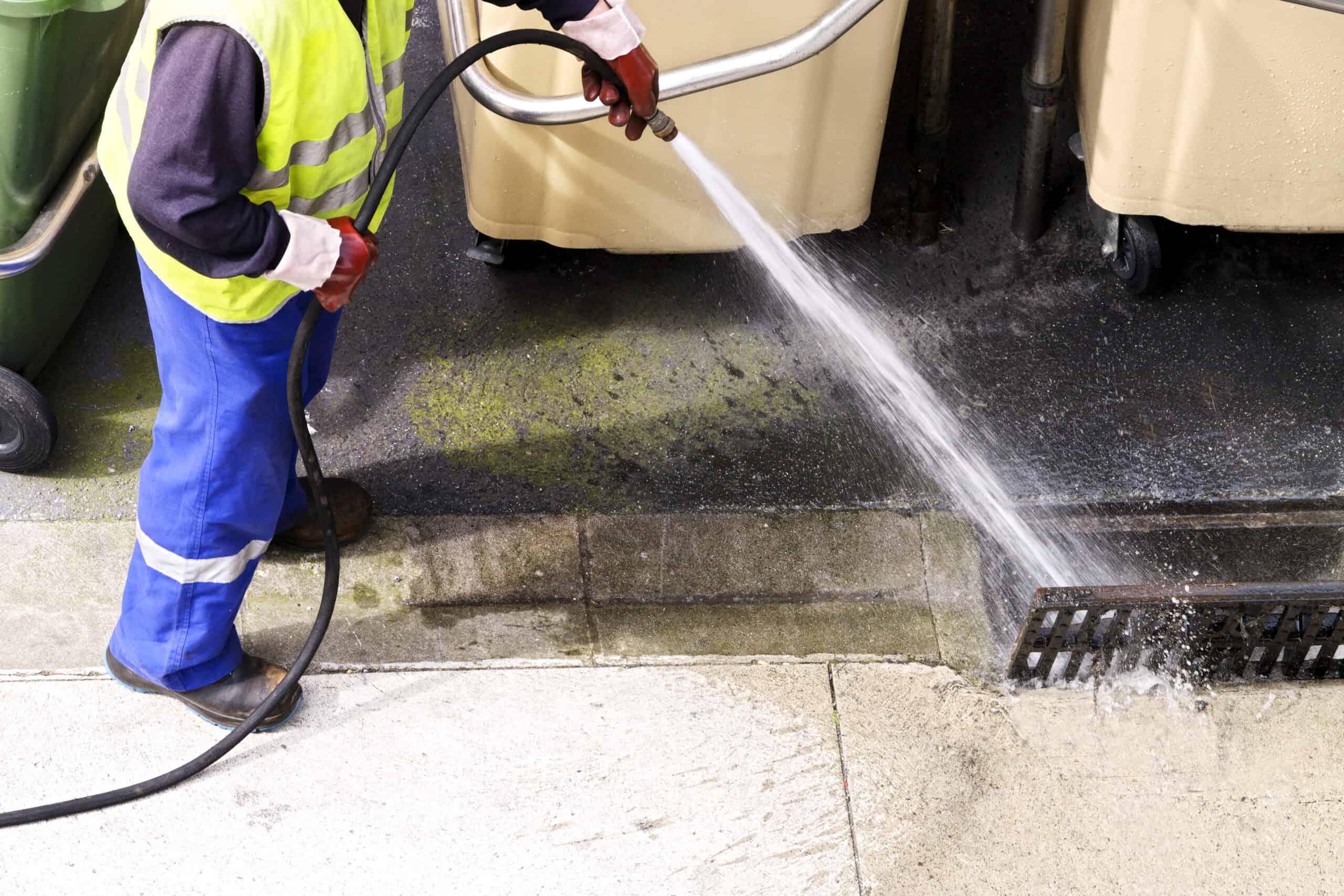Plumber hydro jetting a drain line