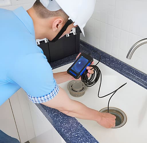Plumber using drain snaking to check for clogs