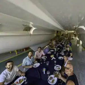 Underwater view of a large Antares Catamaran during a group celebration, showcasing the spacious hulls and sleek design of the vessel.