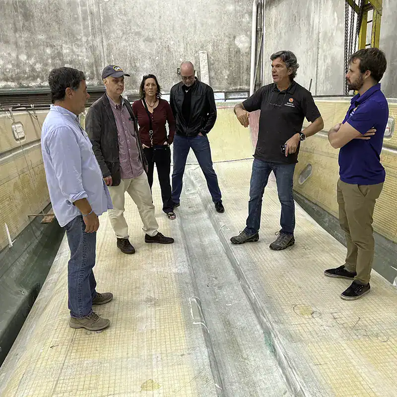 Modern Antares Catamarans manufacturing facility with team discussing boat production and design. Showcasing advanced construction techniques and expert craftsmanship in luxury sailing yachts.
