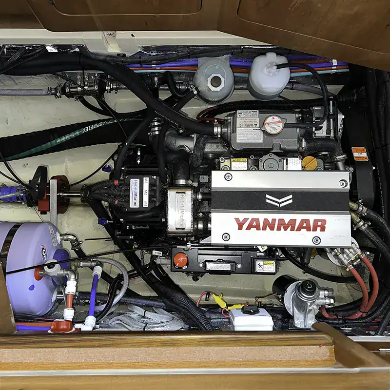 Yanmar marine engine with black hoses and electrical connections inside an Antares catamaran engine compartment, showcasing high-performance propulsion systems.