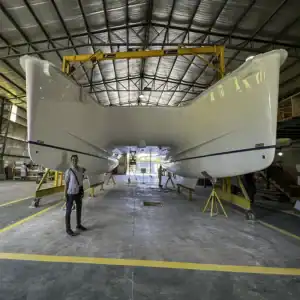 Antares Catamarans boat manufacturing facility showcasing large, modern catamaran hulls under construction in a spacious indoor workshop.