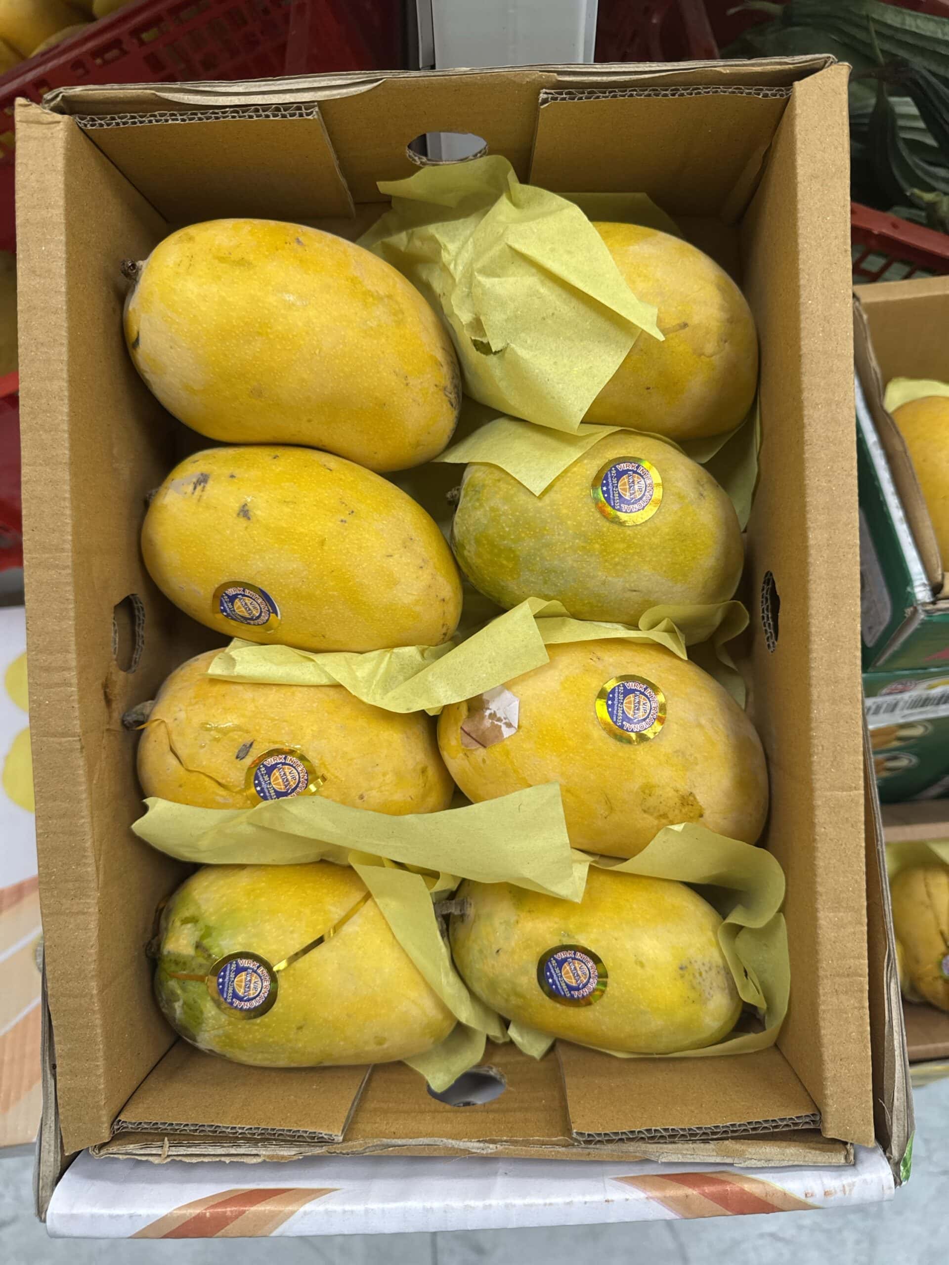 Frische asiatische Mangos im Karton, ideal für den Online-Kauf.